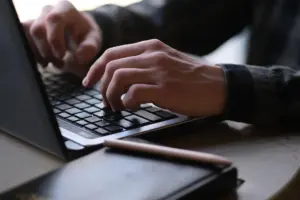 Writer typing a tech article on a laptop